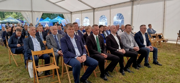 Na zdjęciu widać osoby siedzące na krzesłach, które słuchają prezentacji tematów związanych z rolnictwem ekologicznym.